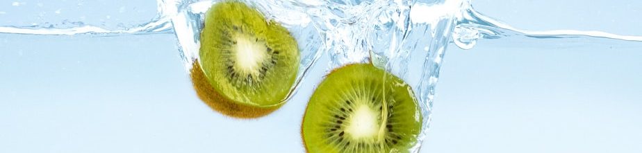 Fresh cut kiwi with clear water splash